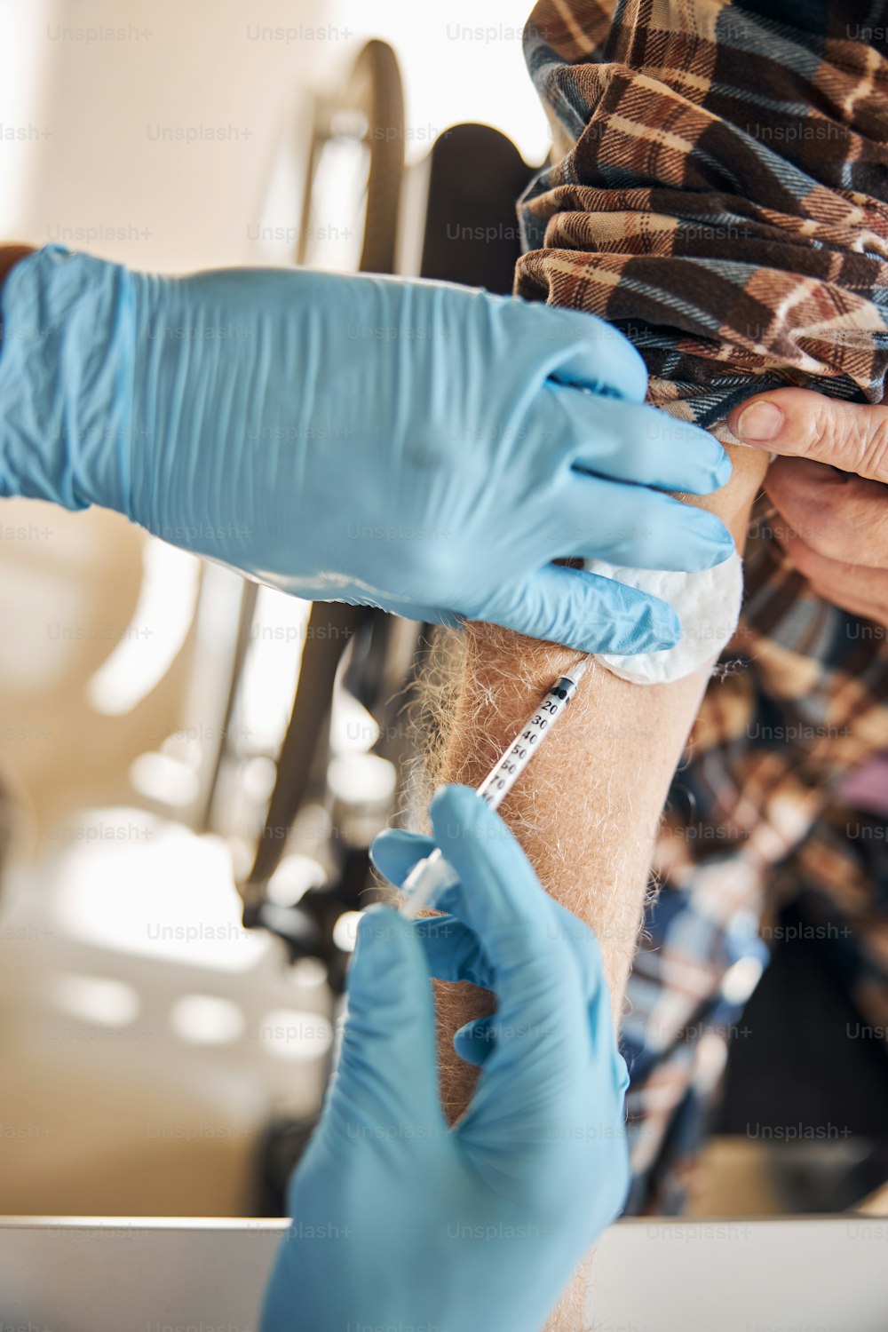 Cropped photo of an experienced doctor in latex gloves injecting insulin into the patient arm