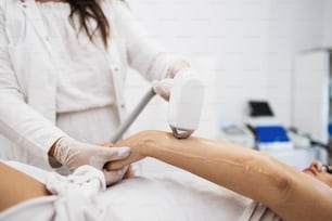 Young beautiful woman receiving arm and body skin epilation treatment. Modern body care and cosmetics concept.