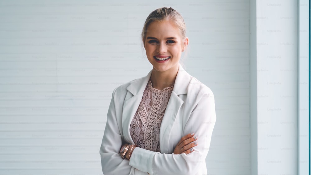 Attractive young woman profile portrait in office . Confident business person wearing formal suit working in corporate business.