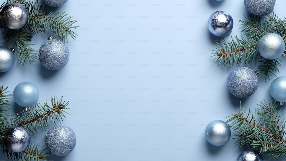Blue Christmas background with pine tree branches and shiny balls decoration. Xmas frame, greeting card template, banner mockup. Flat lay, top view, copy space.