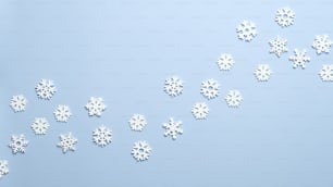 White wooden snowflakes on blue background. Christmas, New Year, winter holidays pattern.