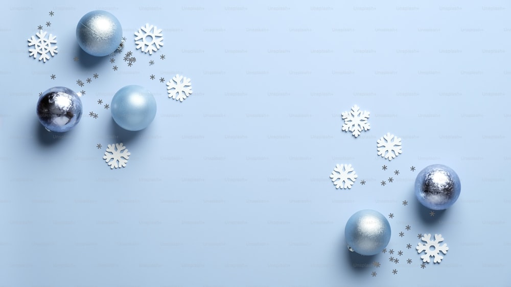 Modern Christmas composition. Shiny balls decoration and white snowflakes on blue background. Flat lay, top view. Christmas, New Year, winter holidays celebration concept.