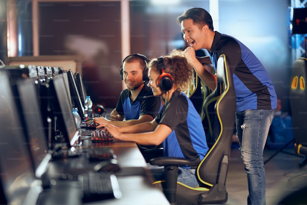 Celebrating success. Team of professional teenage cyber sport gamers participating in eSports tournament, playing online video games