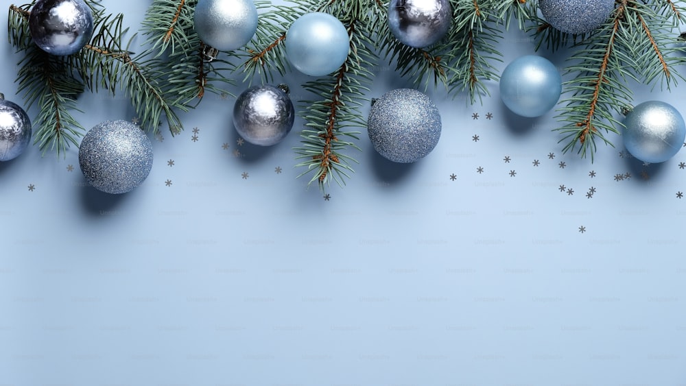 Christmas banner mockup. Flat lay, top view blue and silver balls decoration with pine tree branches on pastel blue background. Christmas, New year, winter holiday celebration concept.