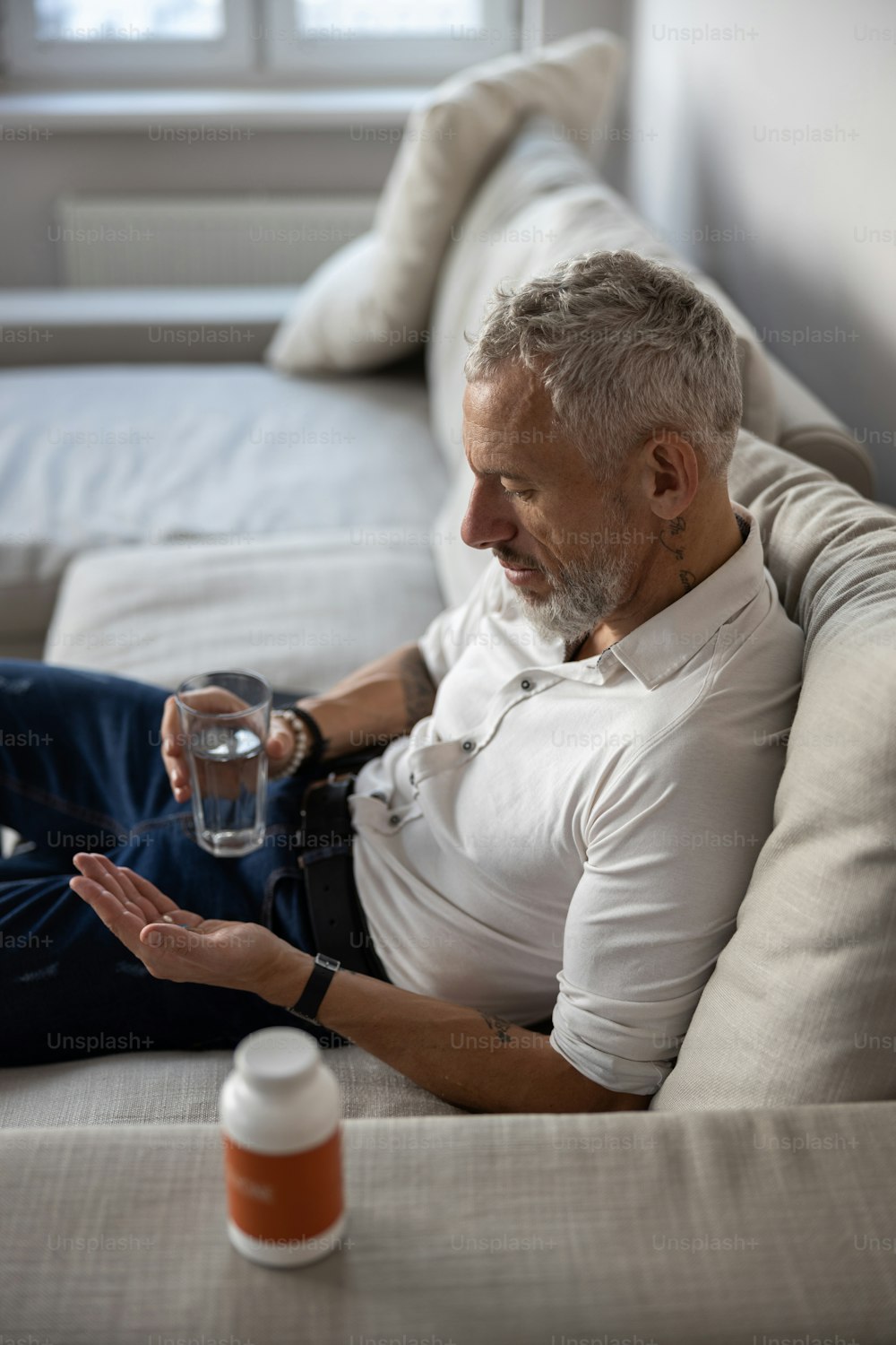 Depressed man getting ready for swallowing his medicine with the help of water in a glass