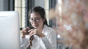Young confident female business worker is sitting in office and drinking coffee ready for the work day.