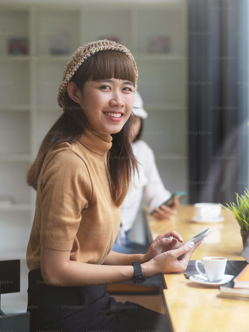 Portrait of female teenager looking into camera while doing assignment in cafe