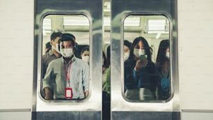 붐비는 공공 지하철 여행에서 안면 마스크를 쓴 사람들의 군중. 코로나바이러스 질병 또는 COVID 19 팬데믹 발생 및 러시 아워 개념의 도시 생활 방식 문제.