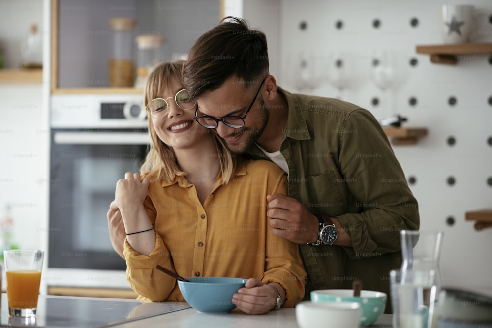 Young couple eating breakfast at home. Loving couple enjoying in the kitchen.