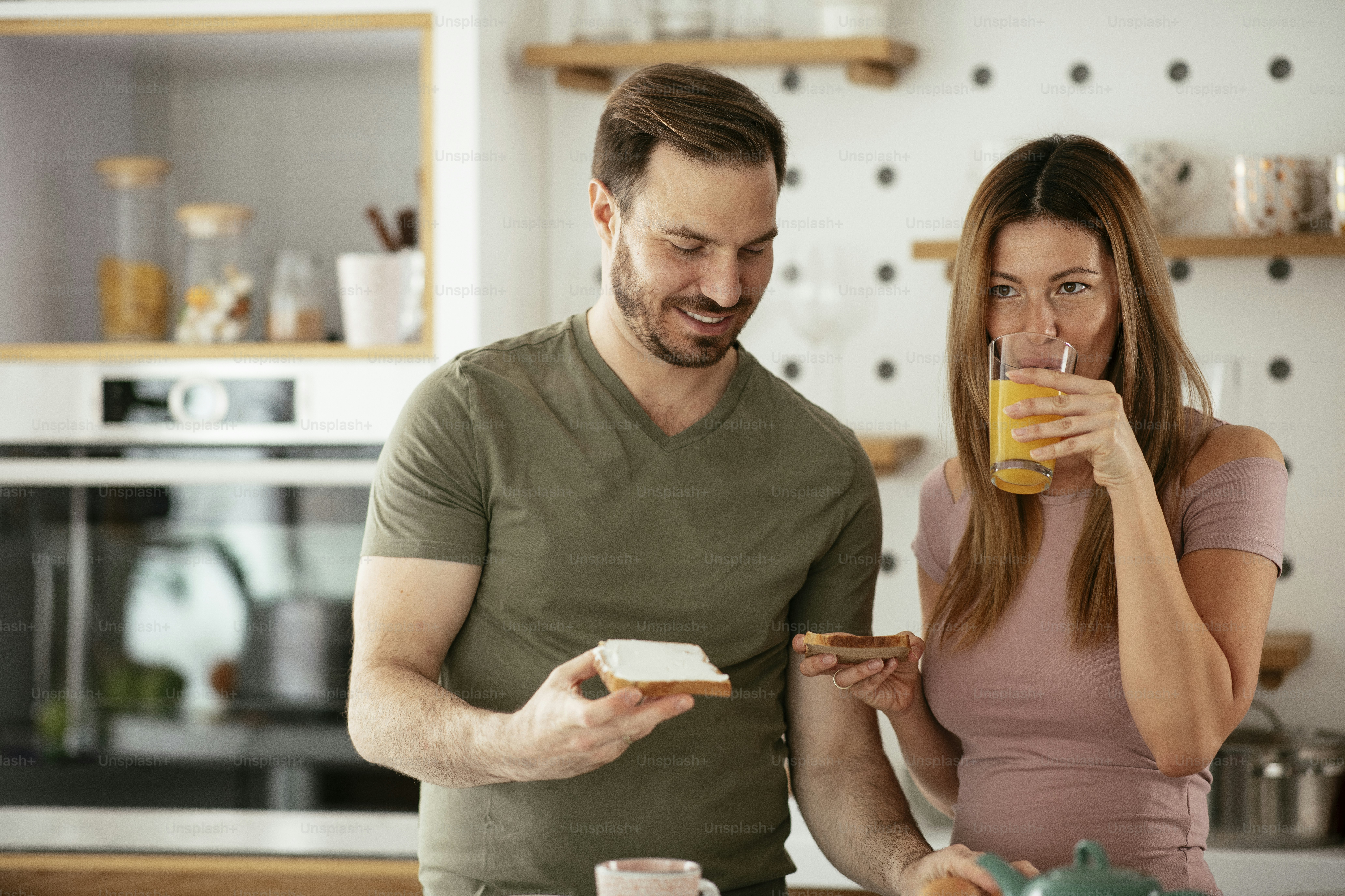 Young couple making sandwich at home. Loving couple enjoying in the kitchen