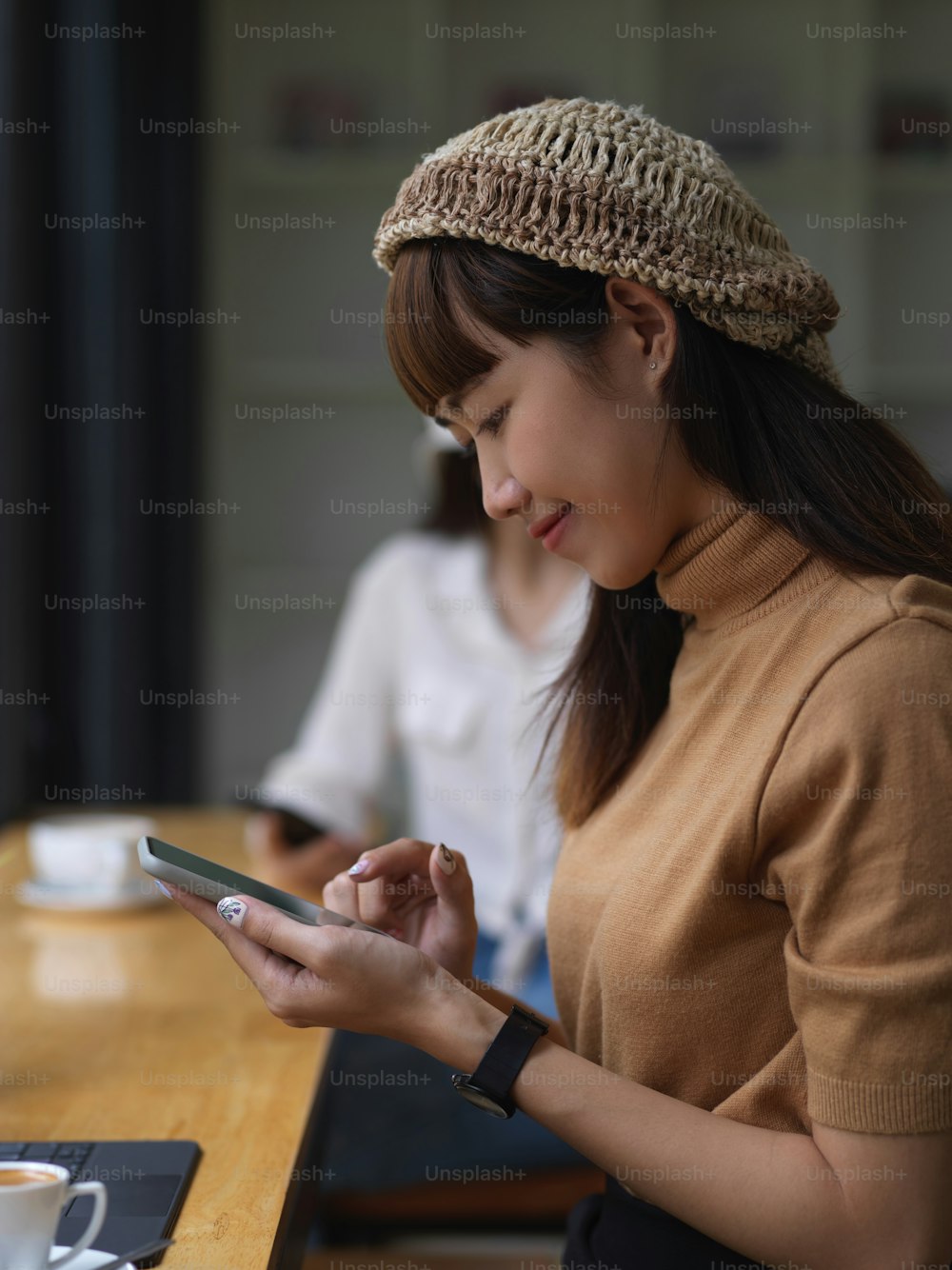Young pretty girl using her smartphone in comfortable workspace
