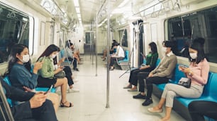 Crowd of people wearing face mask on a crowded public subway train travel . Coronavirus disease or COVID 19 pandemic outbreak and urban lifestyle problem in rush hour concept .