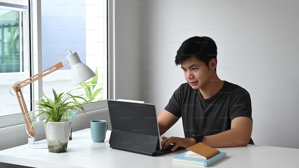 Un joven diseñador analizando datos en una tableta de computadora en el espacio de trabajo.