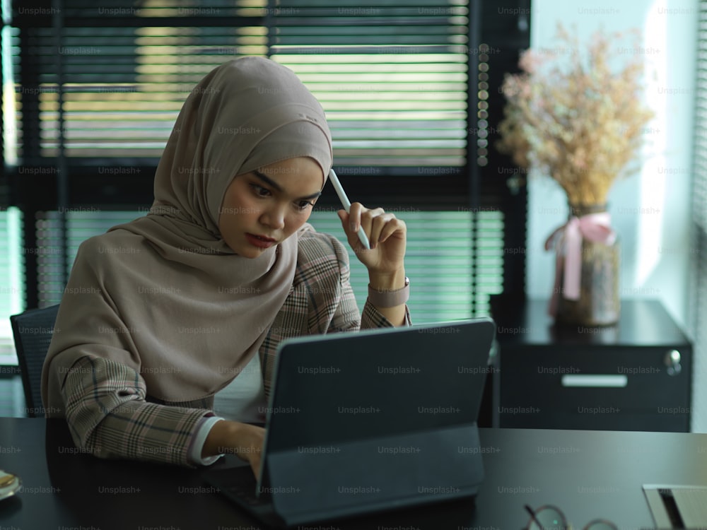 Retrato de una joven mujer de negocios musulmana que se siente estresada mientras trabaja en la oficina
