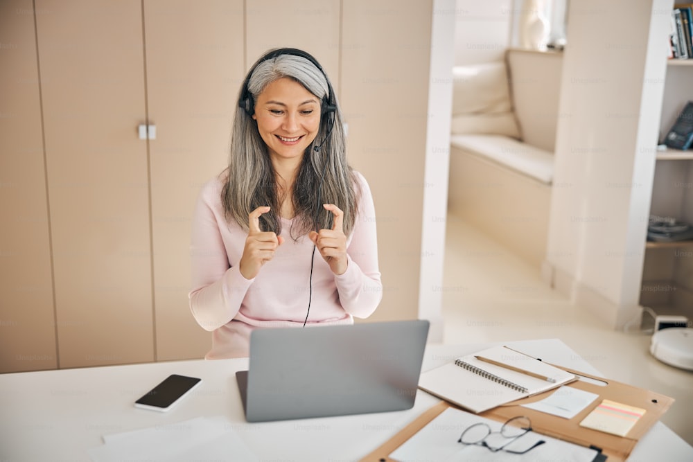 Top view portrait of good looking Asian woman watching lesson sign language online course communicate by conference video call from home