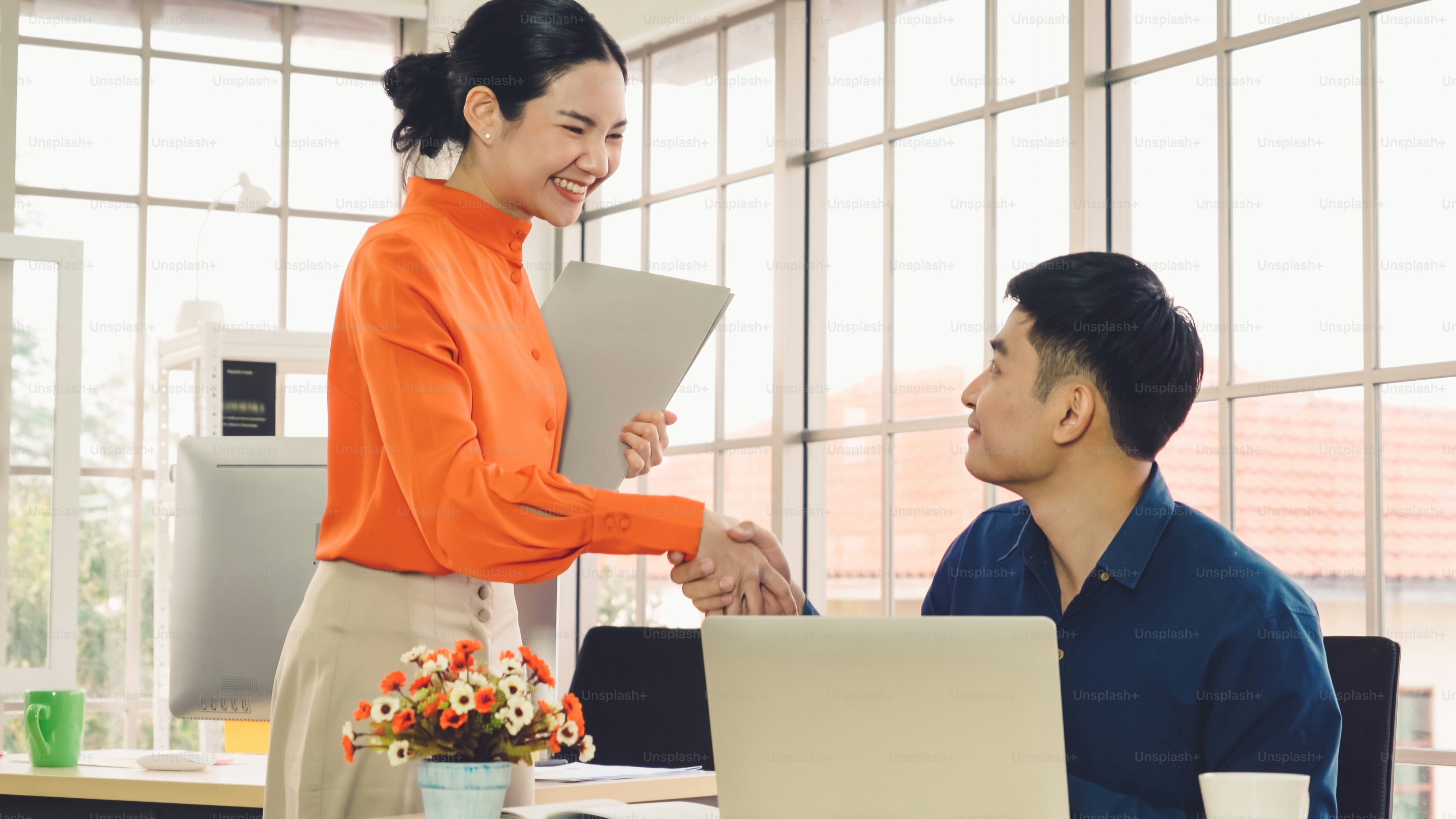 Business people handshake with friend at office showing trust , friendship and success celebration .