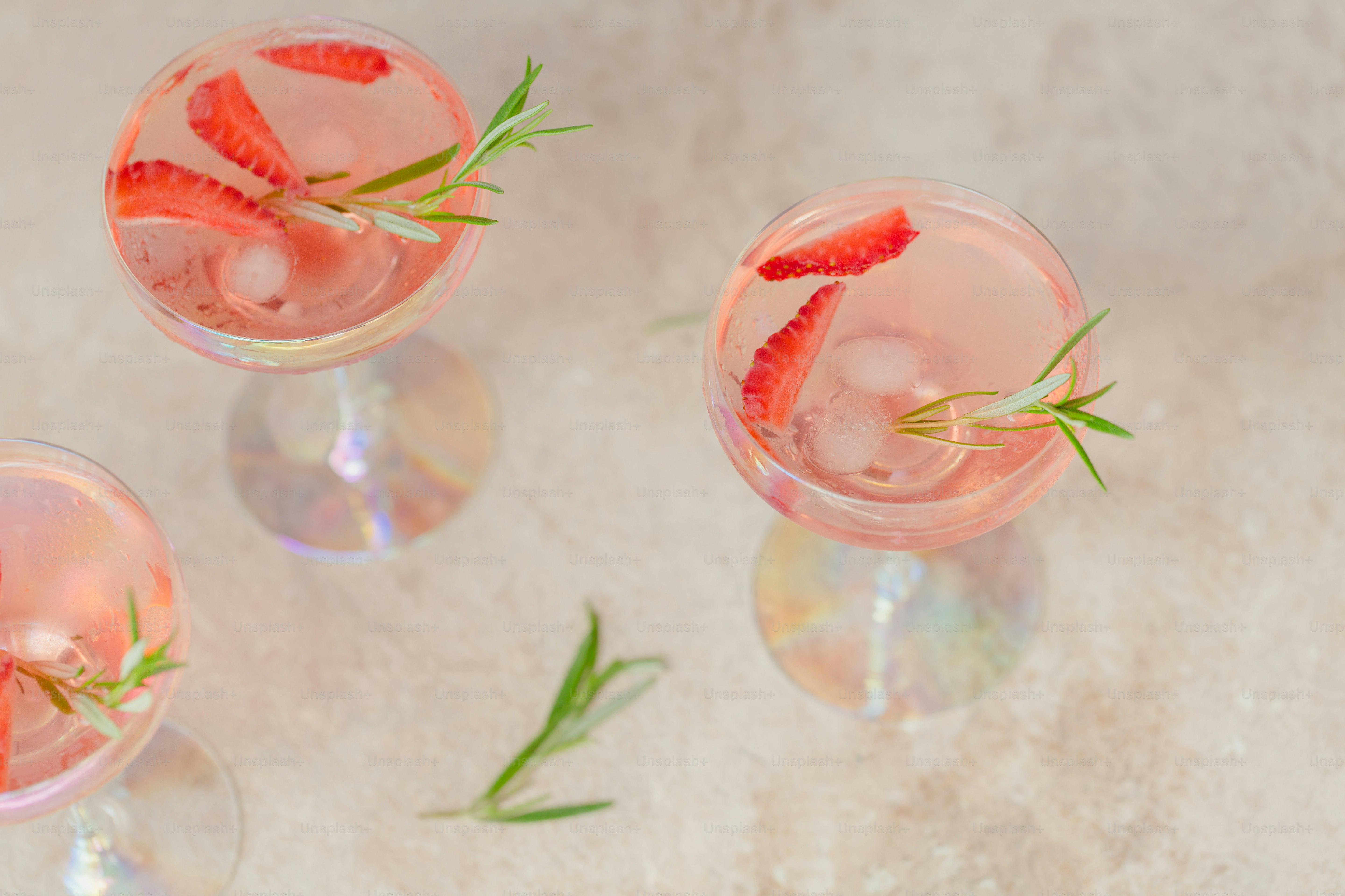 Glass of strawberry soda drink on beige sandy background. Summer healthy detox lemonade, cocktail or another drink background. Low alcohol, nonalcoholic  drinks, super food, vegetarian or healthy diet concept.