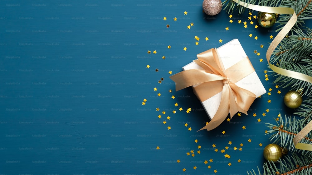 Composition élégante de Noël. Fond de Noël bleu avec boîte-cadeau blanche,  branches de sapin, boules