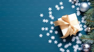 Confezione regalo di Natale, rami di abete, decorazione di palline, fiocchi di neve coriandoli su sfondo blu scuro con spazio di copia. Modello di biglietto di auguri di Natale, mockup di banner di Capodanno.