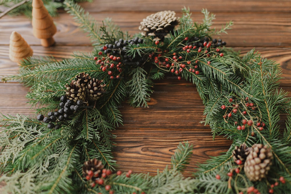 Corona de picea natural de Navidad con decoración seca, caña de pampas y  canela sobre fondo de madera Fotografía de stock - Alamy