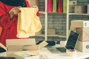 オンライン販売者はホームオフィスで働き、顧客に配送ボックスを梱包します。インターネット上で電子商取引ビジネスを行う中小企業の経営者または起業家。