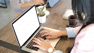 Foto cortada de uma empresária está trabalhando em laptop com display branco isolado na sala de reuniões.