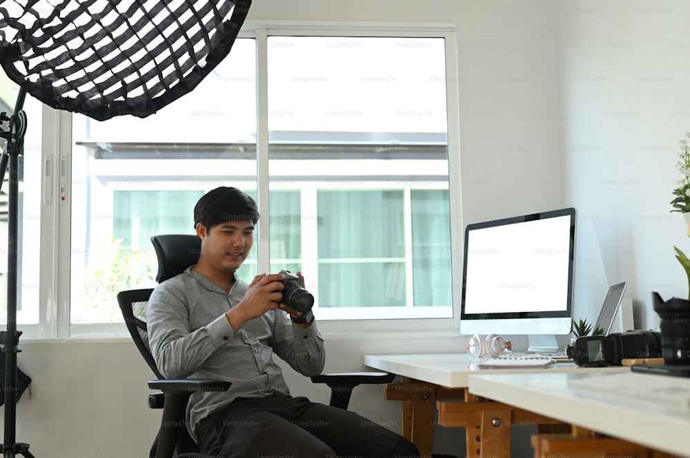 Un grafico o un fotografo che controlla l'immagine sulla fotocamera mentre è seduto nel suo studio.