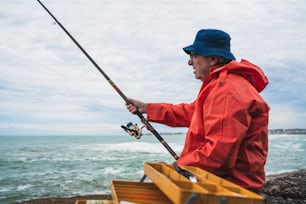 Portrait of an old man fishing in the sea. Fishing concept.