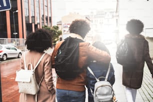 Group of fashionable african students, millennial friends walking on the street, spending time together. Young people lifestyle and friendship concept.