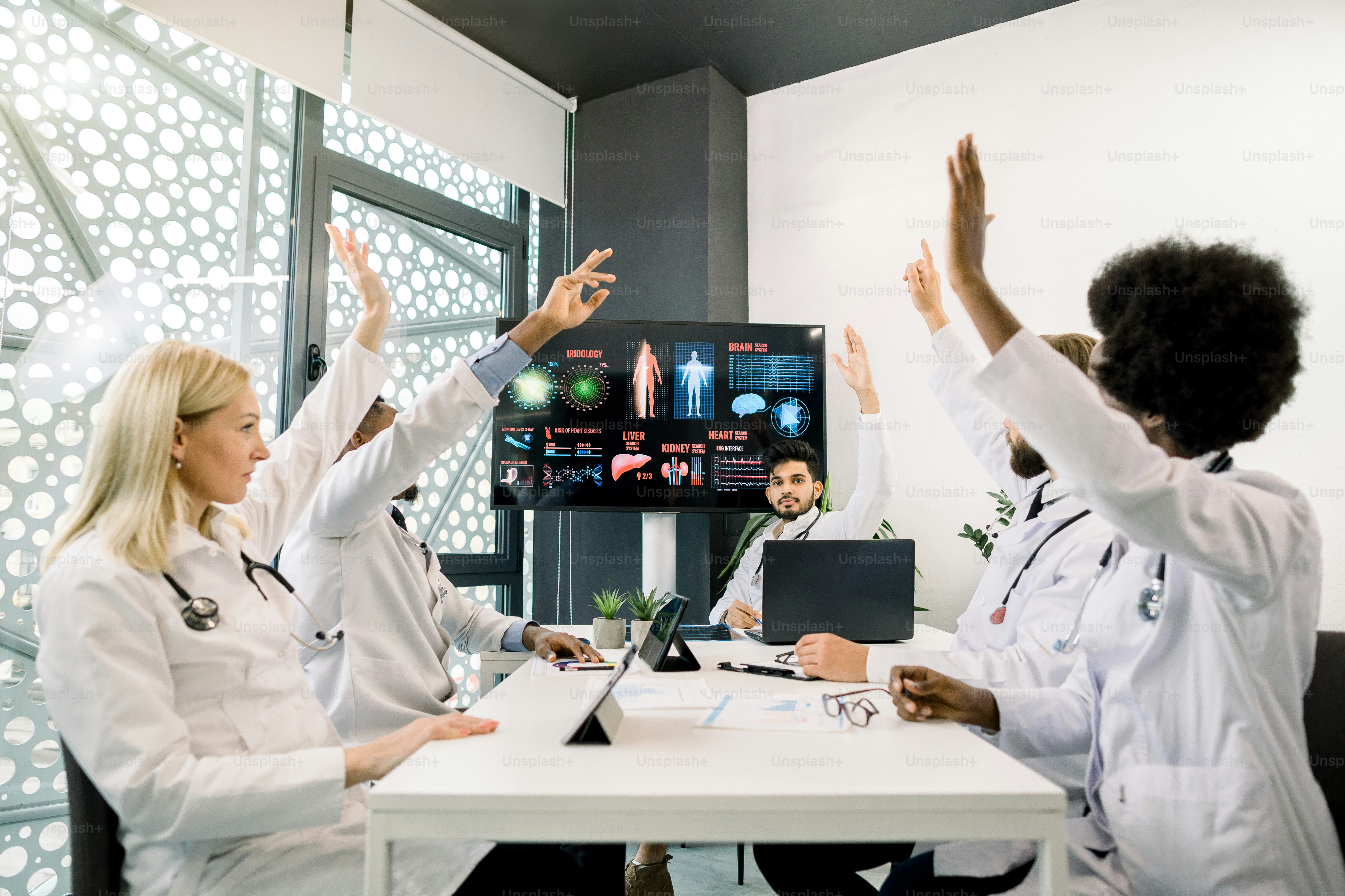 Handsome young Indian man doctor consulting team of multiracial ...