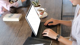 Cropped shot of two businesswoman are working with tablet together at a boardroom table in a modern office.