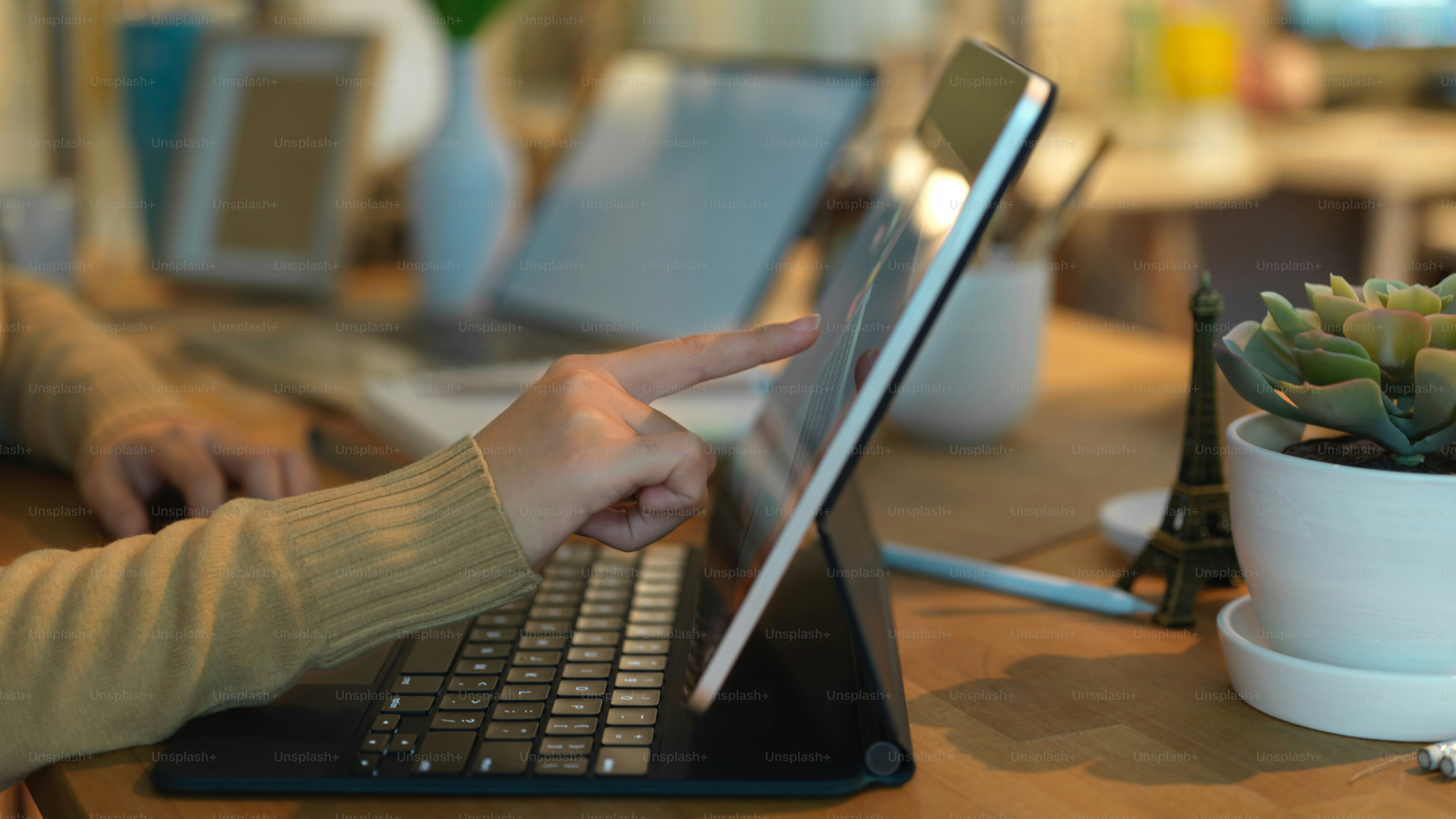 Side view of female finger pointing on laptop screen in office room