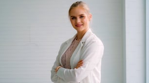 Attractive young woman profile portrait in office . Confident business person wearing formal suit working in corporate business.