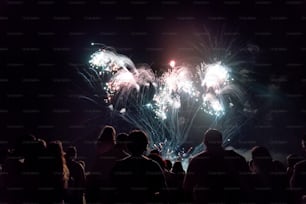 Multitud viendo fuegos artificiales y celebrando el año nuevo