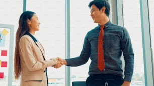 Business people handshake in corporate office showing professional agreement on a financial deal contract.