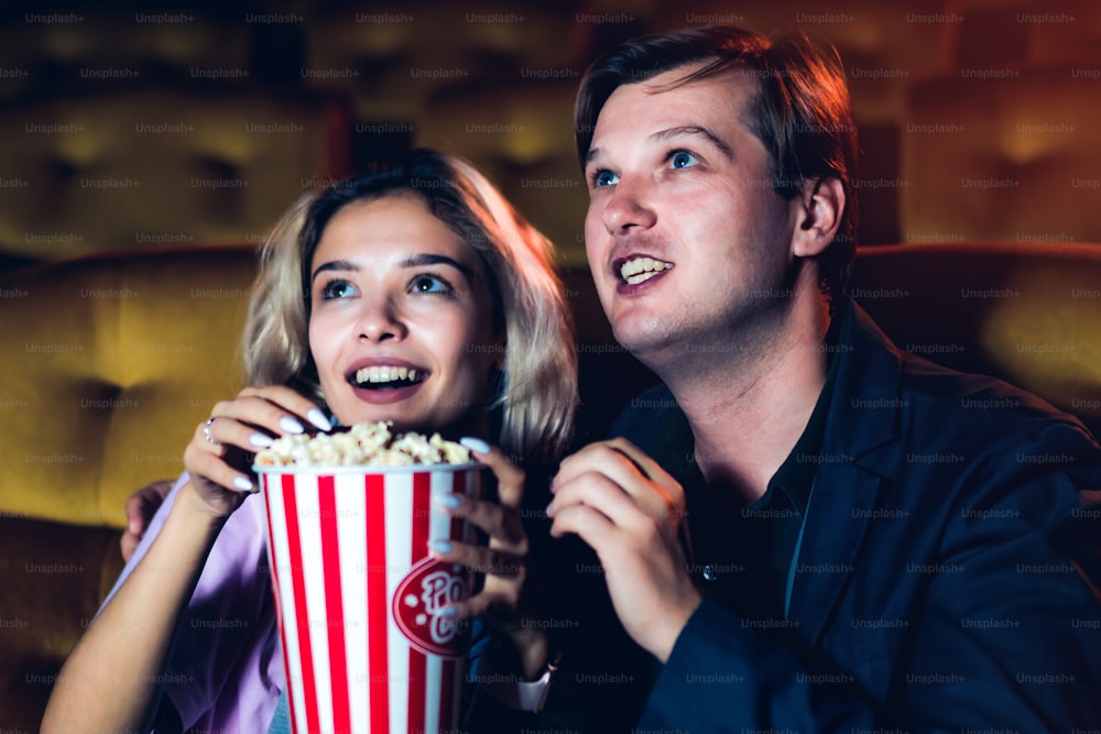 Amante caucásico disfrutando de ver películas y comiendo palomitas de maíz juntos en el cine
