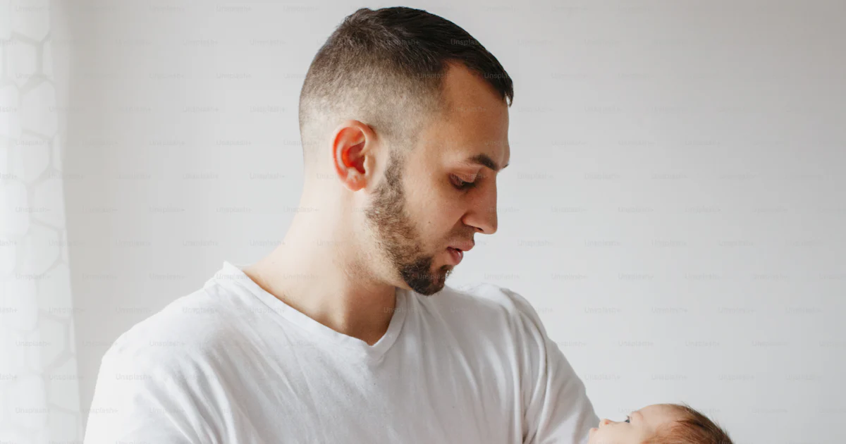 Young Caucasian father trying to calm down newborn baby. Male man ...
