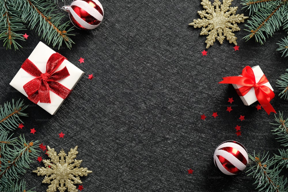 Fondo negro de Navidad con cajas de regalo, copos de nieve dorados, bolas, confeti. Elegante tarjeta de felicitación de Navidad, diseño de banner.