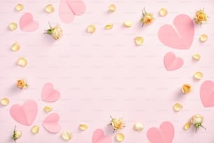Happy Valentines Day Konzept. Gestell aus Papierherzen, Rosenblütenblättern und Knospen auf pastellrosa Hintergrund. Flaches Lay, Draufsicht, Kopierraum. Grußkartenvorlage zum Valentinstag, Banner-Mockup.