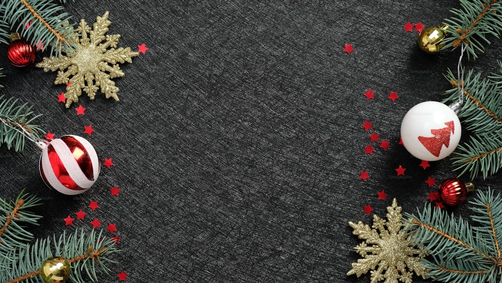 Fond de Noël noir de luxe avec décoration de boules rouges et blanches, flocons de neige dorés, confettis. Maquette de bannière de Noël, conception de carte de voeux du Nouvel An.