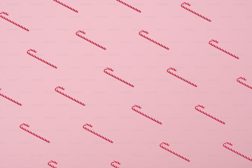 파스텔 핑크 배경에 사탕 지팡이의 패턴입니다. 최소한의 스타일. 크리스마스 개념입니다.
