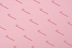 Pattern of Candy canes on pastel pink background. Minimal style. Christmas concept.
