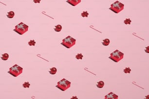 Motif de Noël composé de boîtes cadeaux rouges, de cannes de bonbon, de décorations, de boules sur fond rose. Noël Nouvel An, concept de vacances d’hiver.