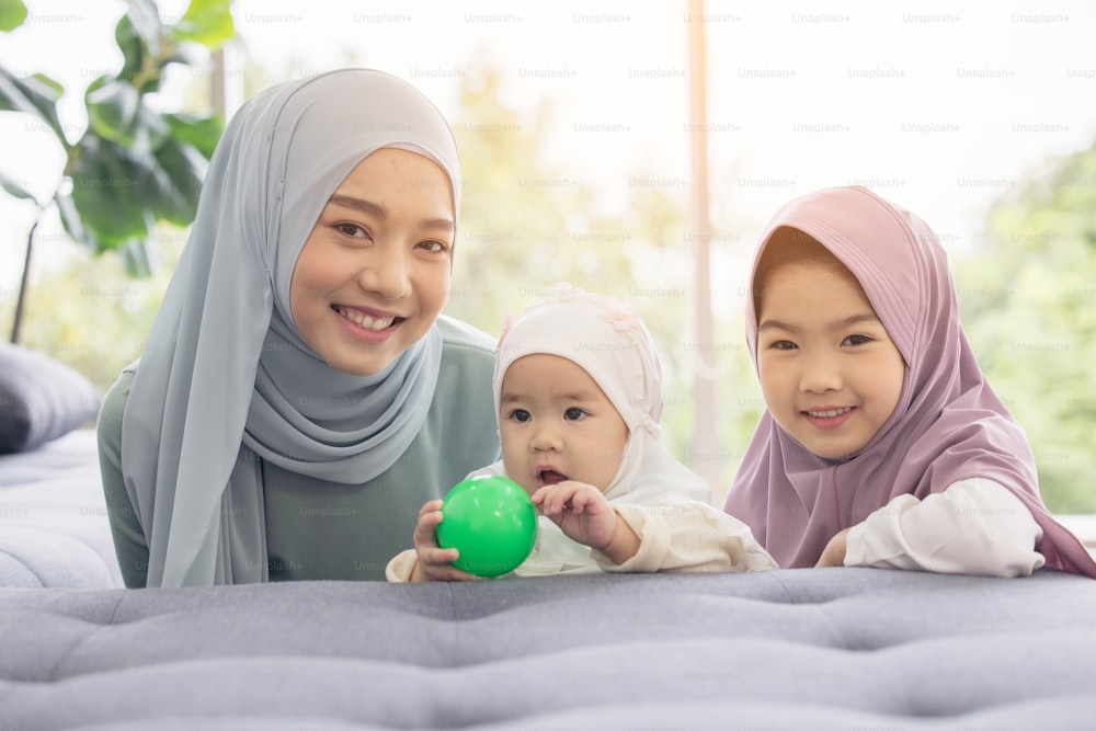 Una madre musulmana con hiyab es su hija pequeña sentada en la sala de estar, Relación amorosa