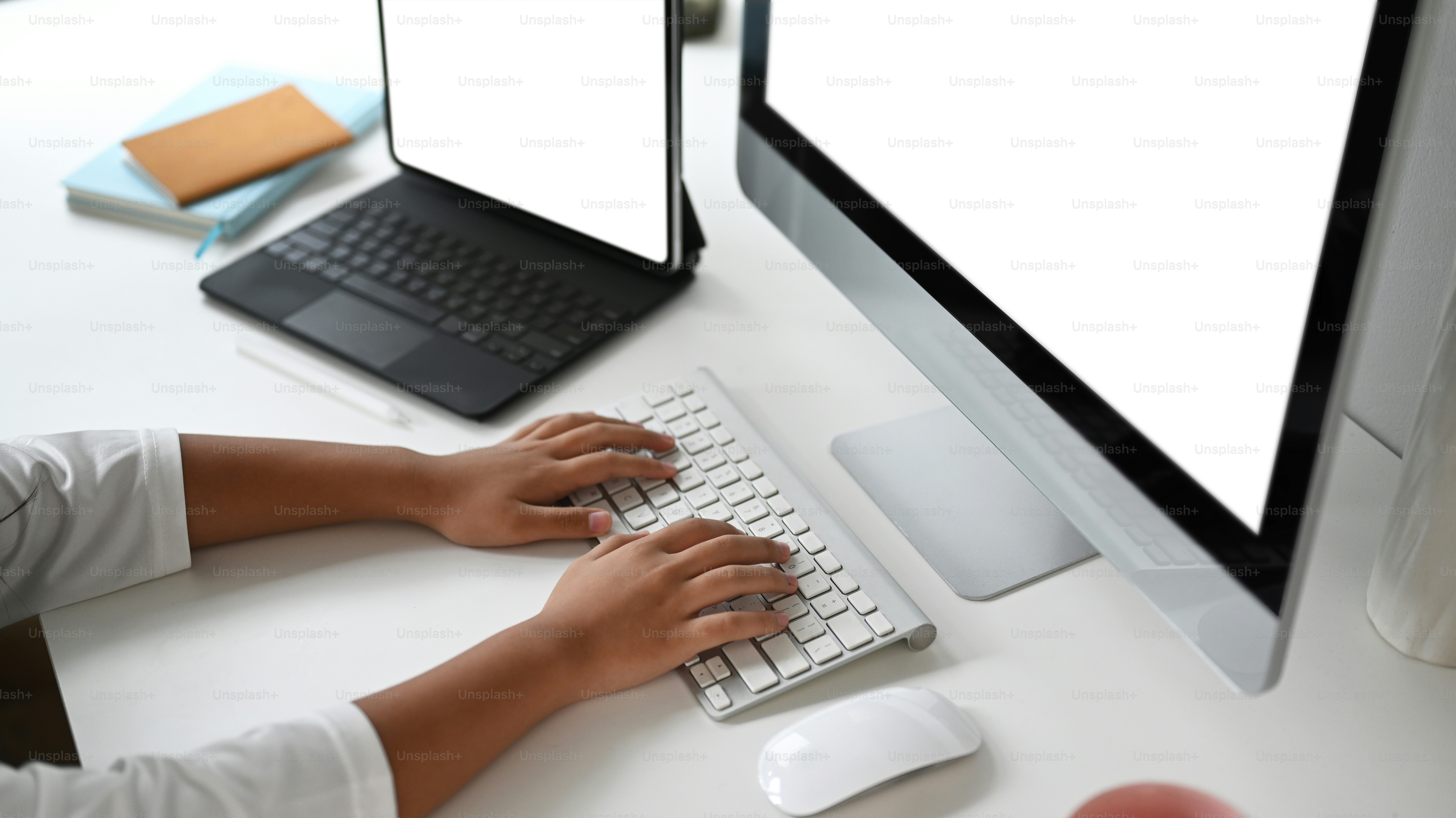 Colpo ritagliato di un uomo d'affari sta lavorando su più schermi di computer alla scrivania dell'ufficio.