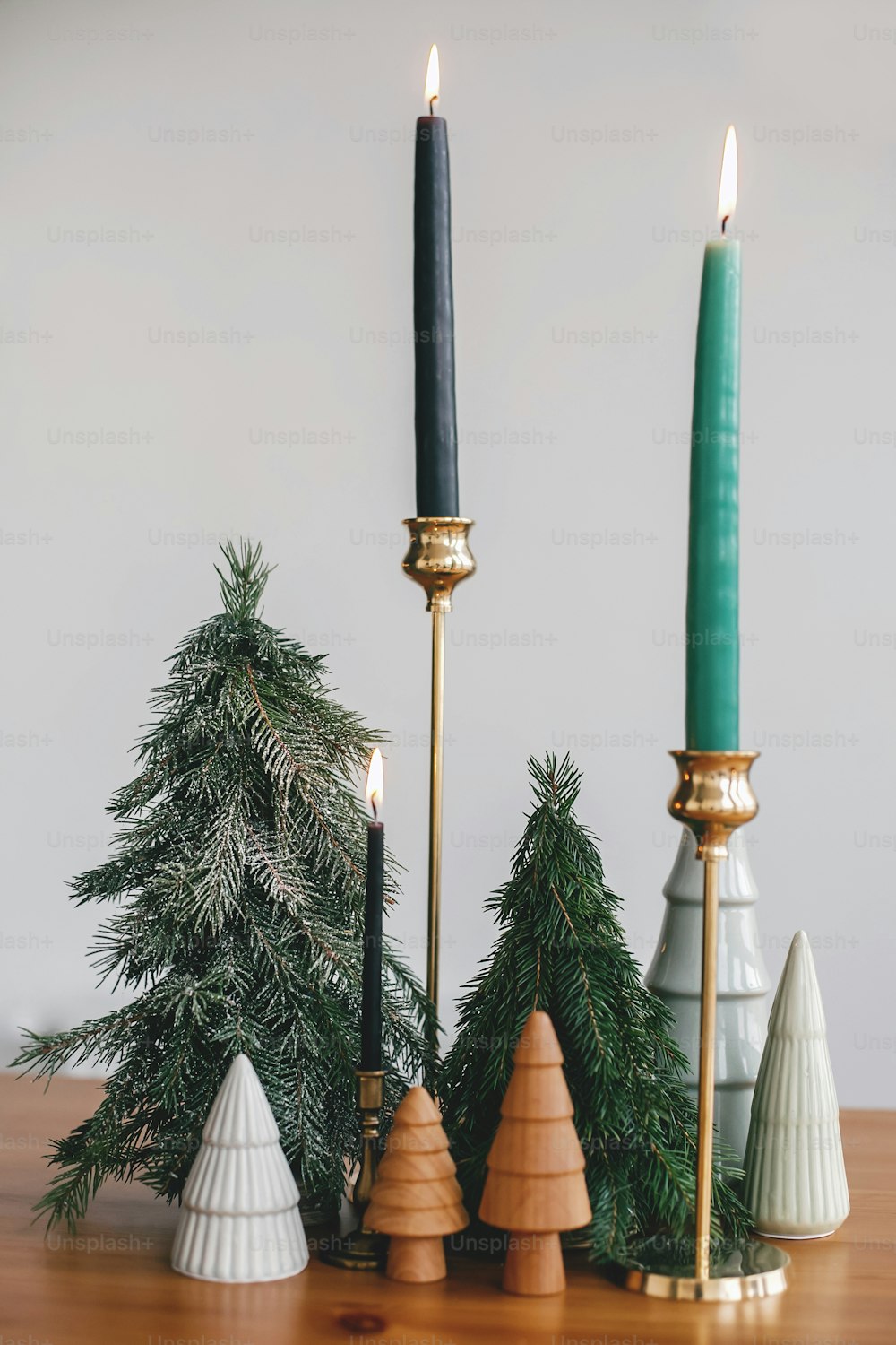 Alberi di Natale, candele e pigne su tavolo rustico in legno. Arredamento festivo moderno a rifiuti zero. Abeti in miniatura in legno e fatti a mano. Buone Feste