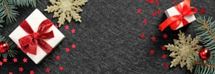 Christmas header or banner design. White gift boxes with red ribbon bow, confetti, golden snowflakes, fir tree branches on black background.