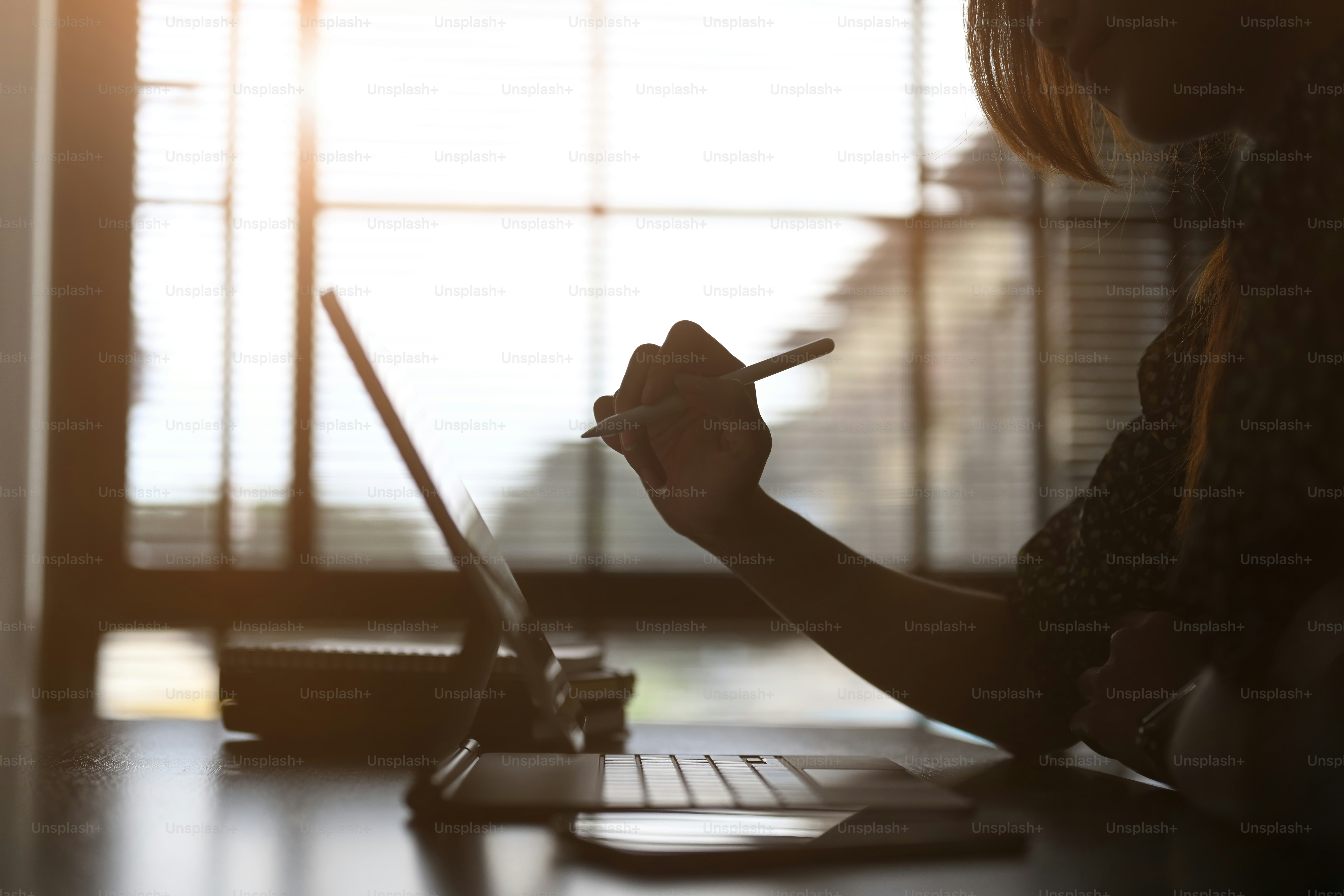 A graphic designer woman using digital tablet designing creative ideas and planning on her project at the contemporary office.