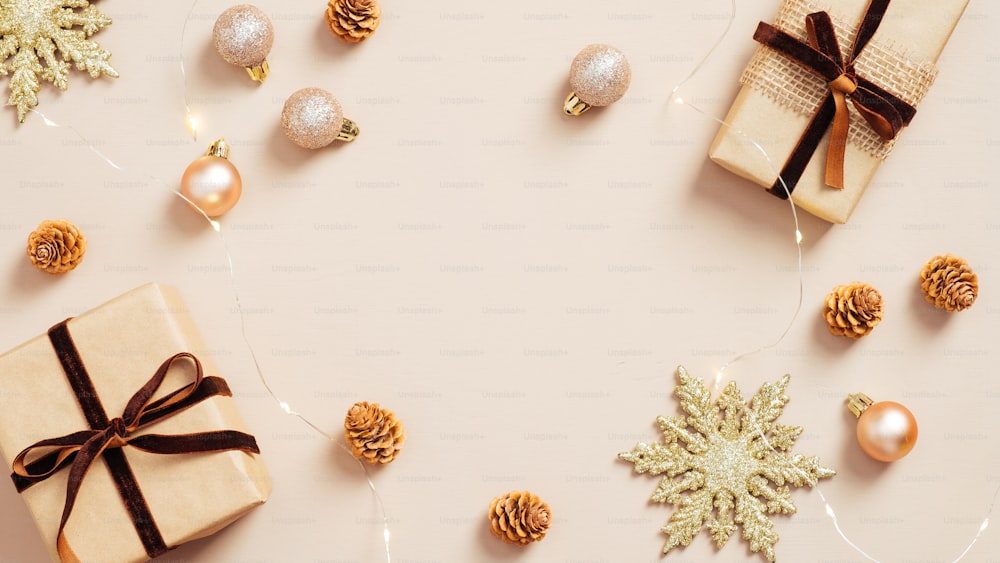 Decorazioni natalizie moderne e scatole regalo su sfondo beige pastello. Posa piatta, vista dall'alto.