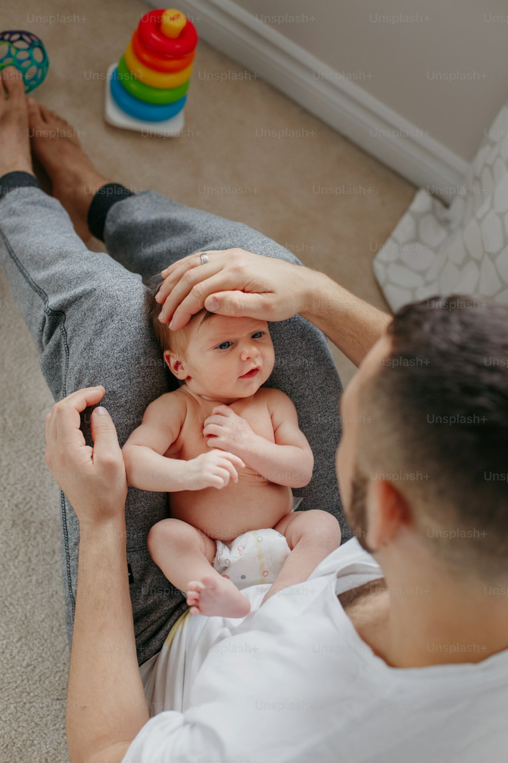 Happy Caucasian father holding newborn baby on laps knees. Man parent embracing rocking child daughter son. Authentic lifestyle candid moment. Proud young dad. Family fathers day.
